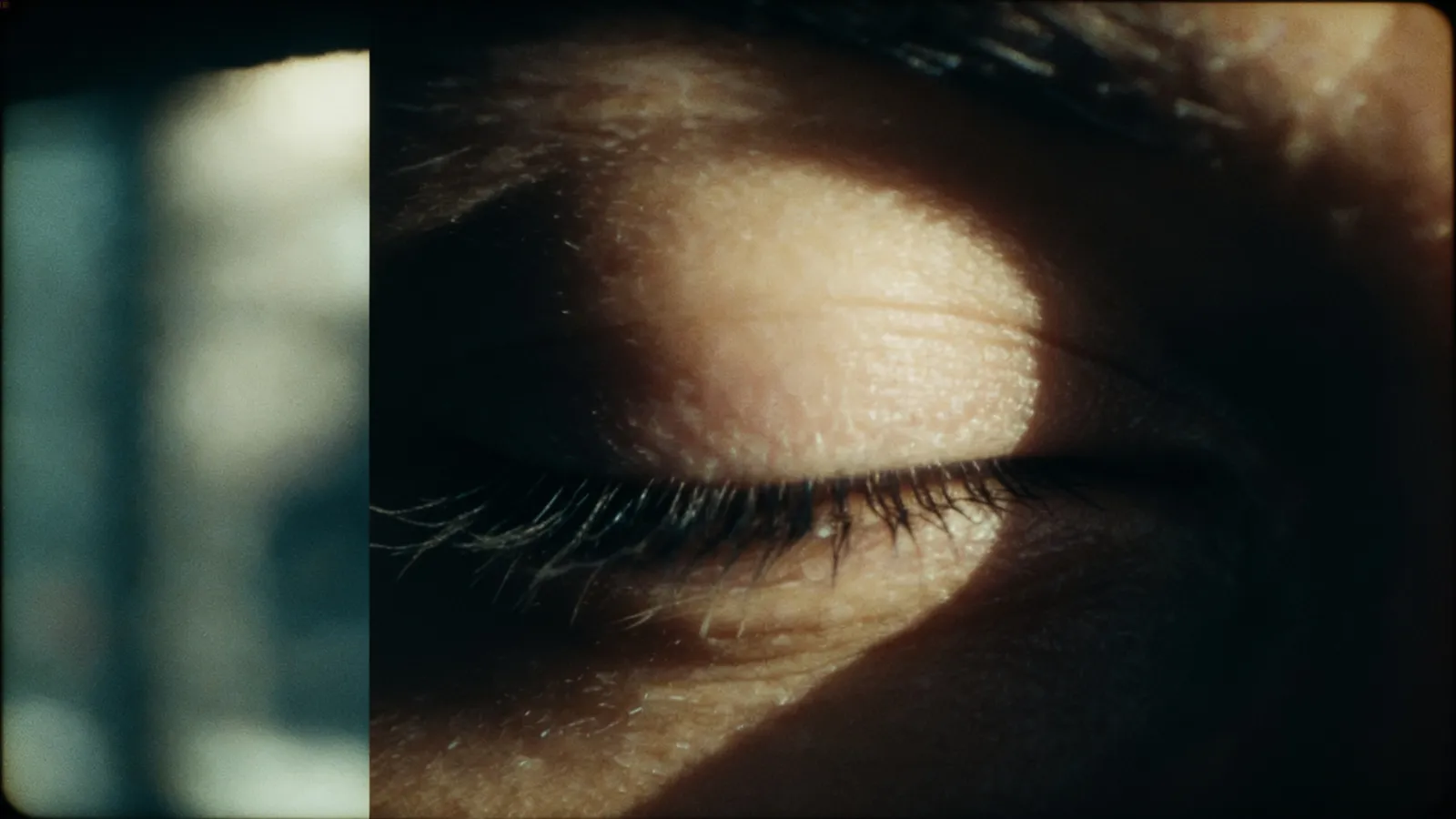A closed eye in the TISHA grade, half-lit, a shadow falling across the lashes.